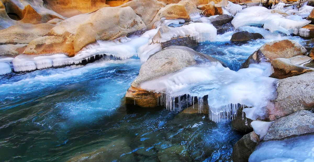 帕米尔高原的冬天河水结冰冰河下面水继续流淌冰河和水的颜色在强烈的