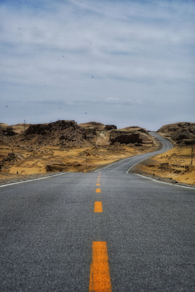 一条公路独自穿越在沙漠中