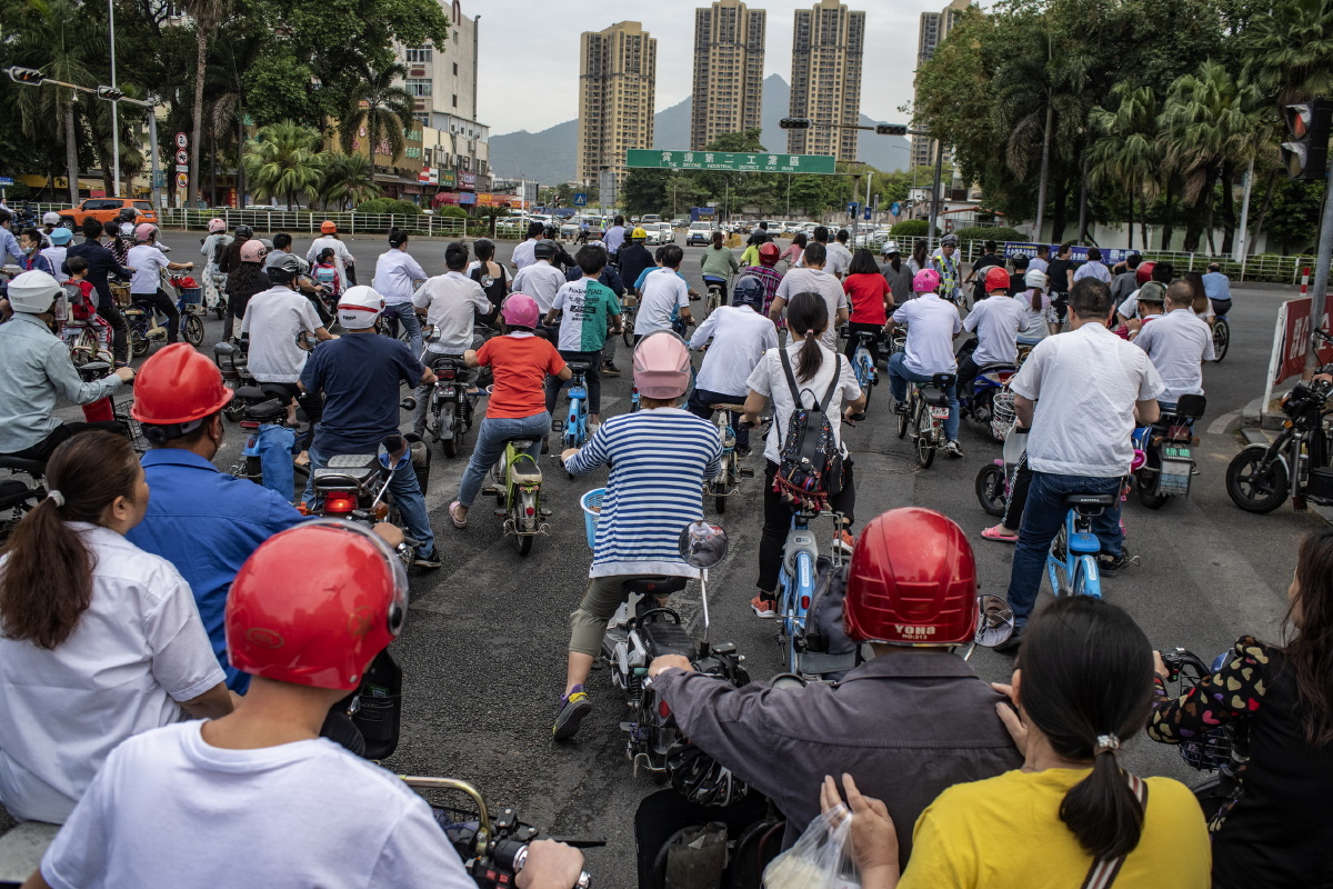 2021年4月21日,广东省东莞市.打工者离开出租屋,骑电动自行车去上班.