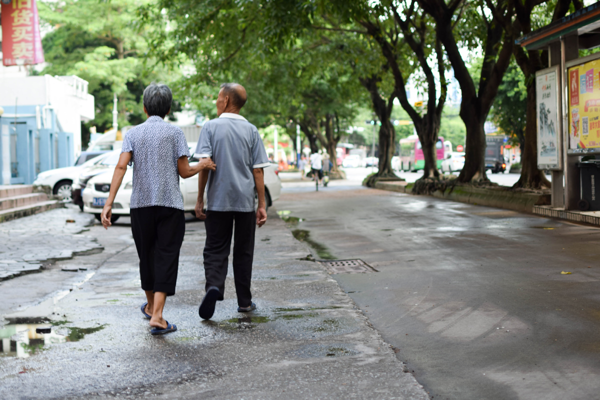 一对老夫老妻搀扶着走路,时不时给老伴指指看一些有意思的东西