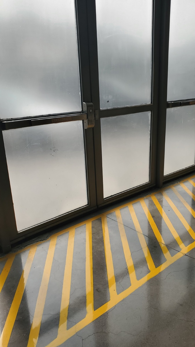 磨砂玻璃门与地面黄色警戒线警戒标志