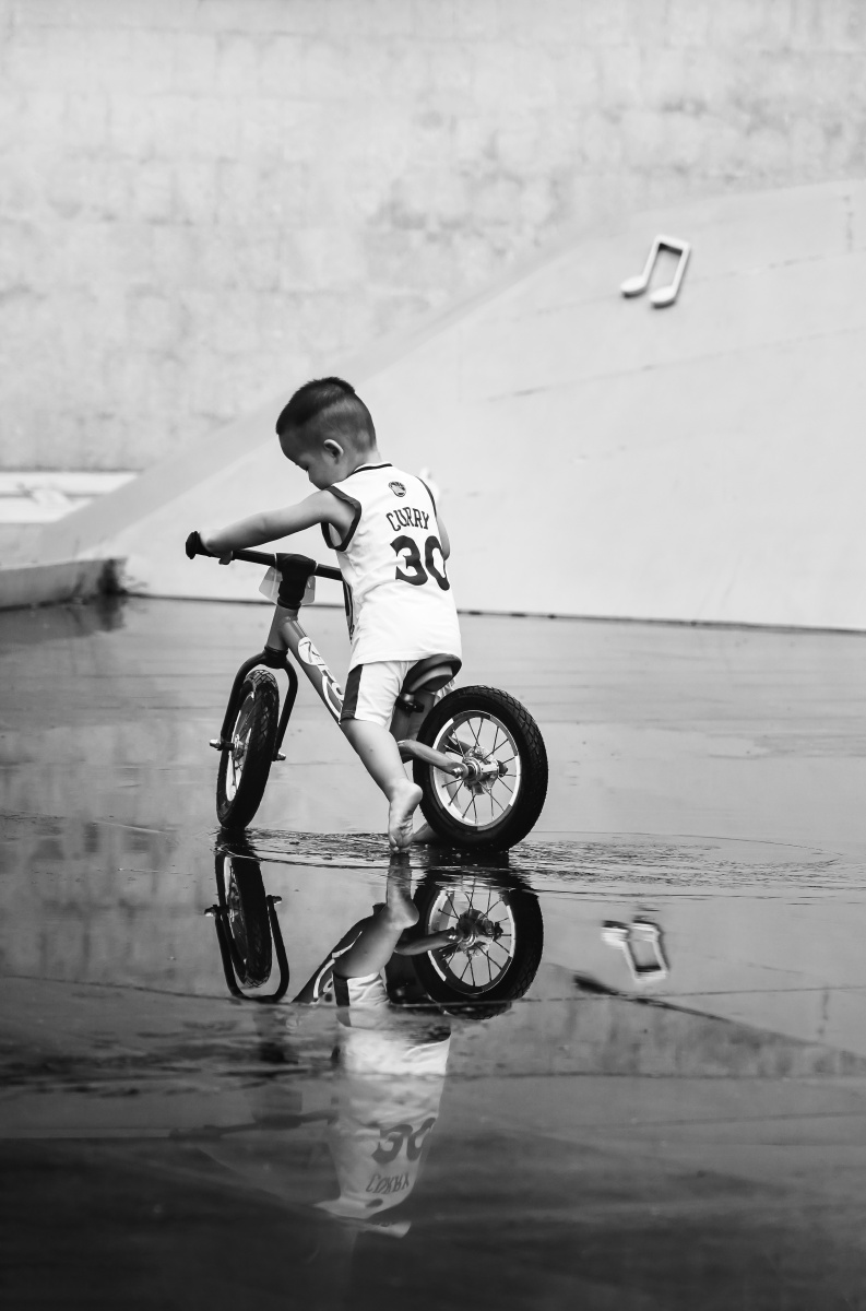 骑单车玩水的小男孩