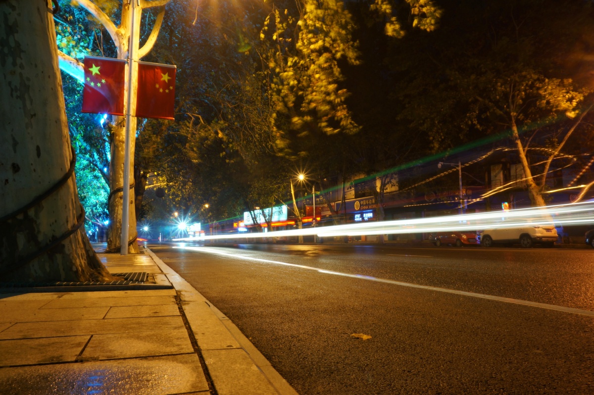 城市街头国庆的旗帜与路边川流不息的车流