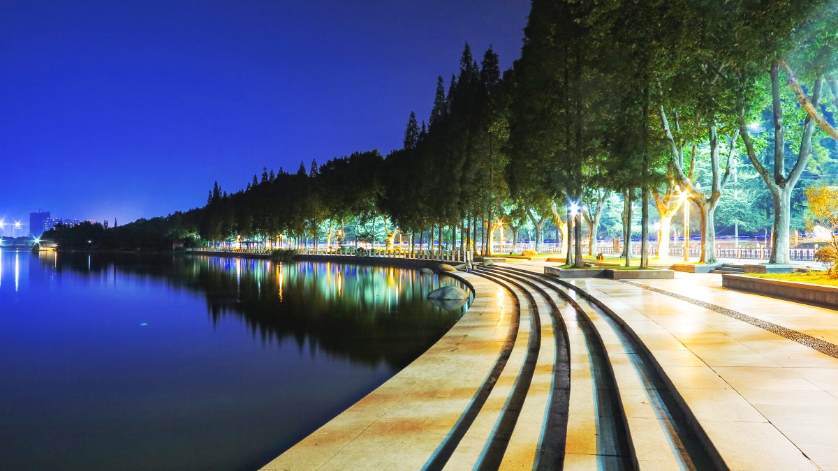 晴朗夏日夜晚宁静的湖北襄阳古城护城河边的滨水景观