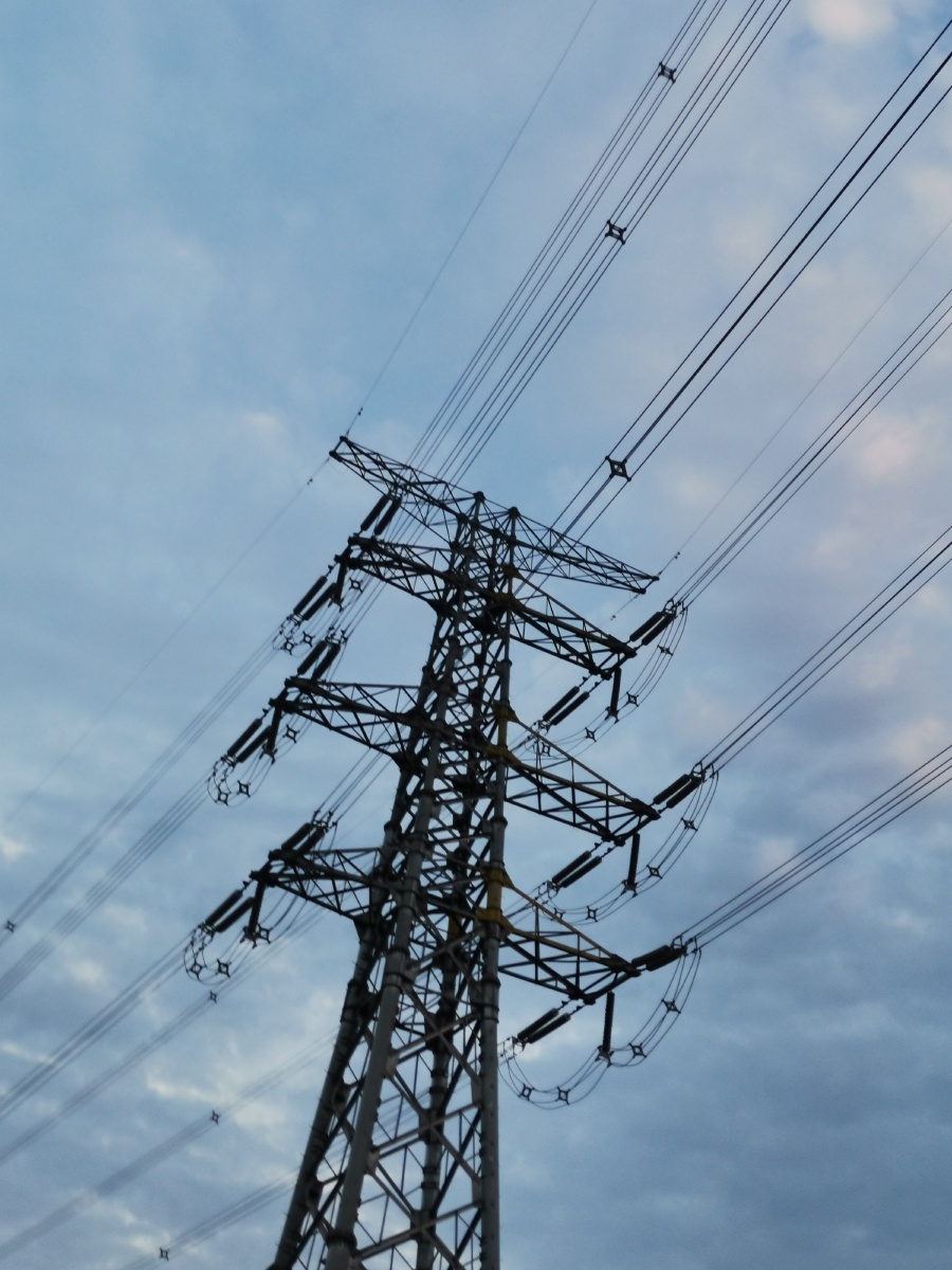 蓝天白云下威严的高压铁塔