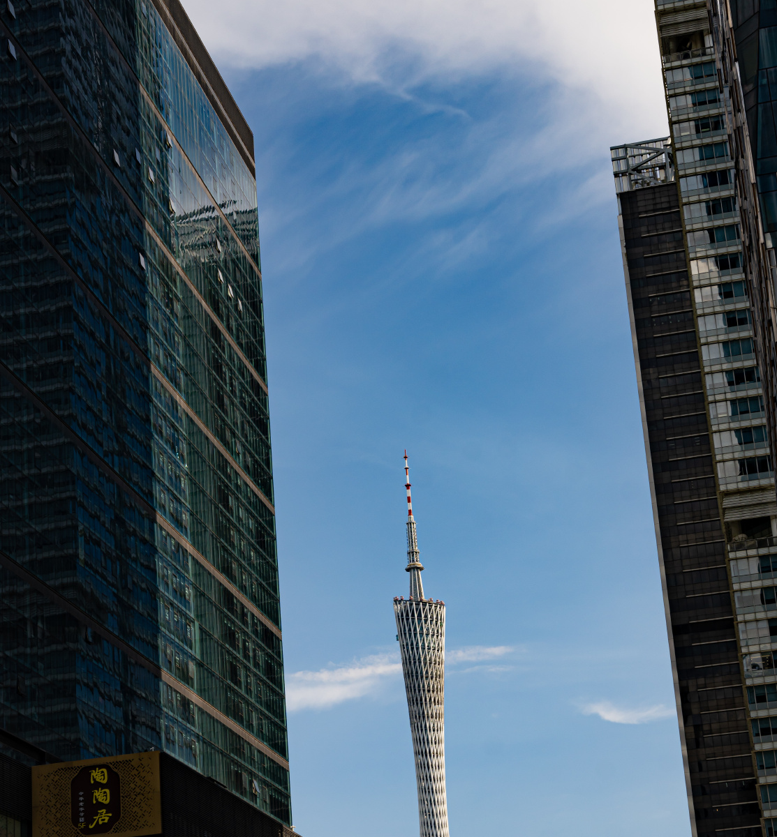 蓝天白云下高楼夹缝中的广州塔