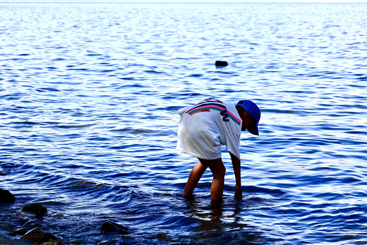 大理洱海边拾贝的小男孩