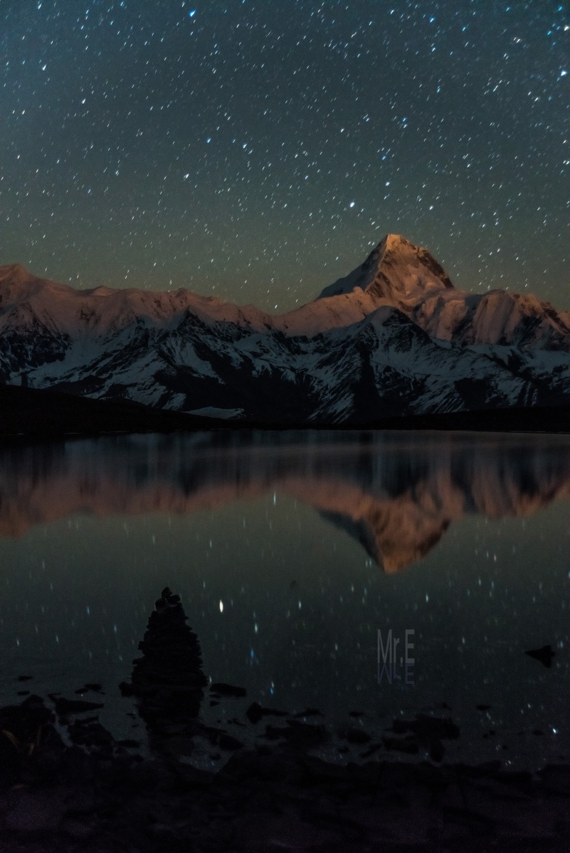 星空下,贡嘎山倒影在冷嘎措的湖面上,与满天繁星相映成趣,一眼万年.
