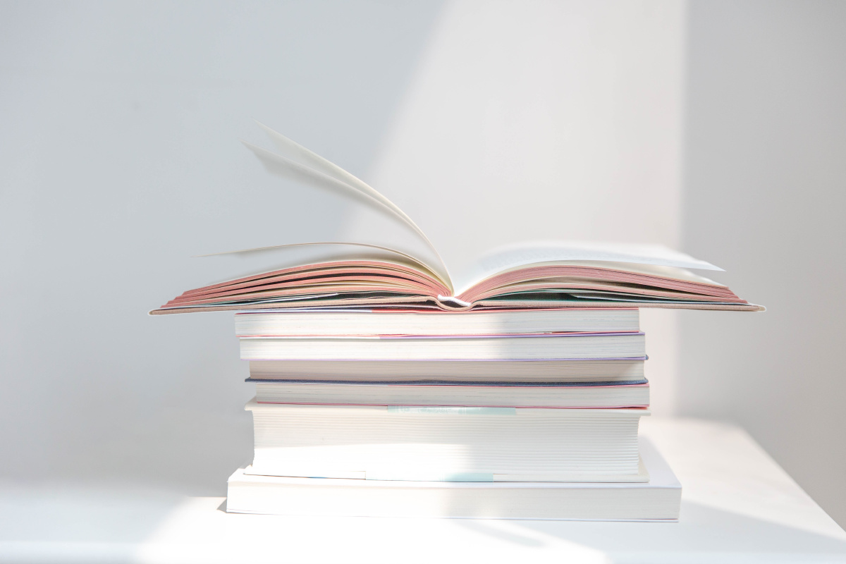 阳光下堆叠在白色背景前的书