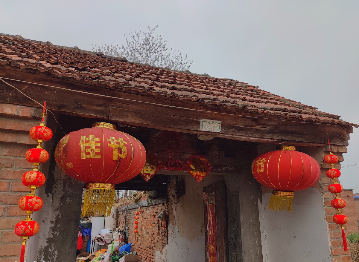 家乡的新年气息淳朴的老百姓在过年的时候大门的两侧总会挂上大红色的