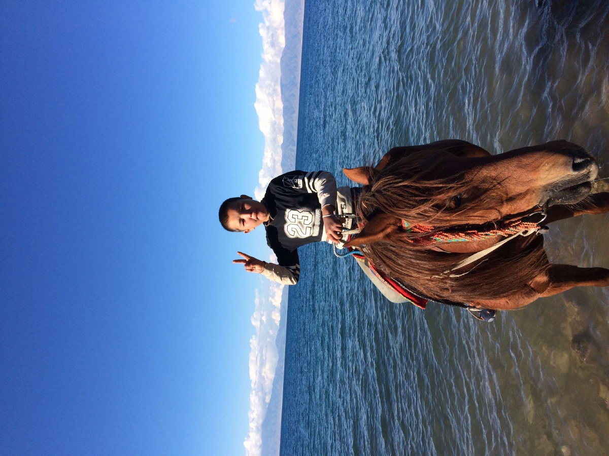 赛里木湖边的骑马少年