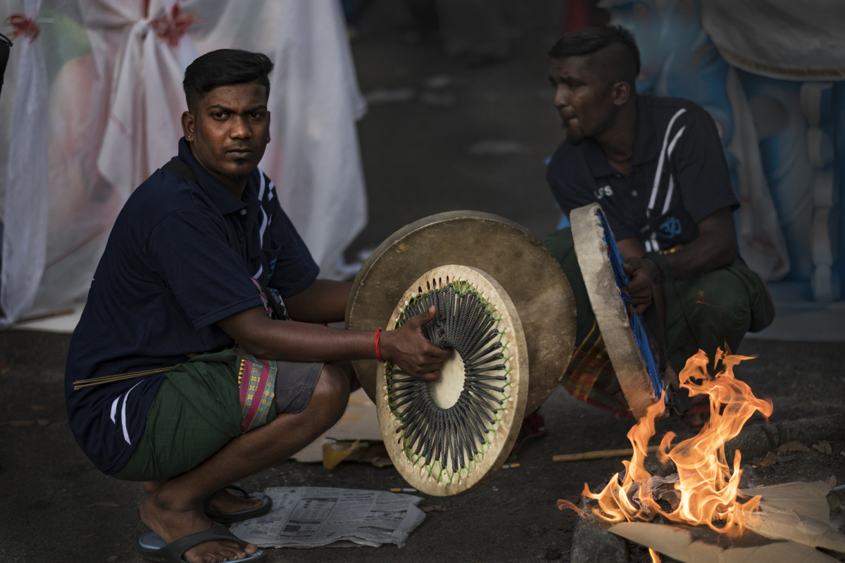 还愿队伍亲友团有印度传统牛皮鼓队助阵添加气氛,在鼓皮不够弹性时