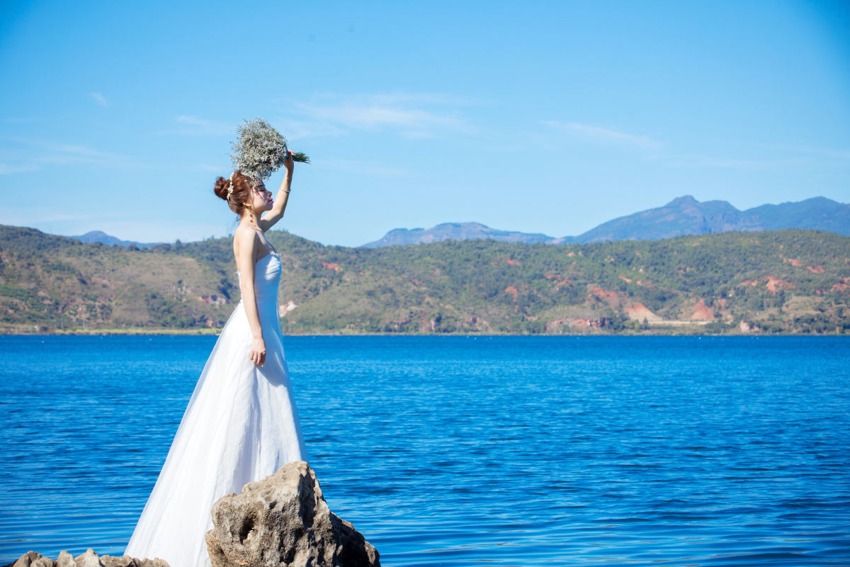 山与海蓝天白云相间独自欣赏礁石做伴穿白纱的姑娘