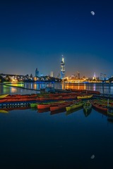 夜色光影中的紫峰大厦和湖面上的船只+玄武湖公园（南京）