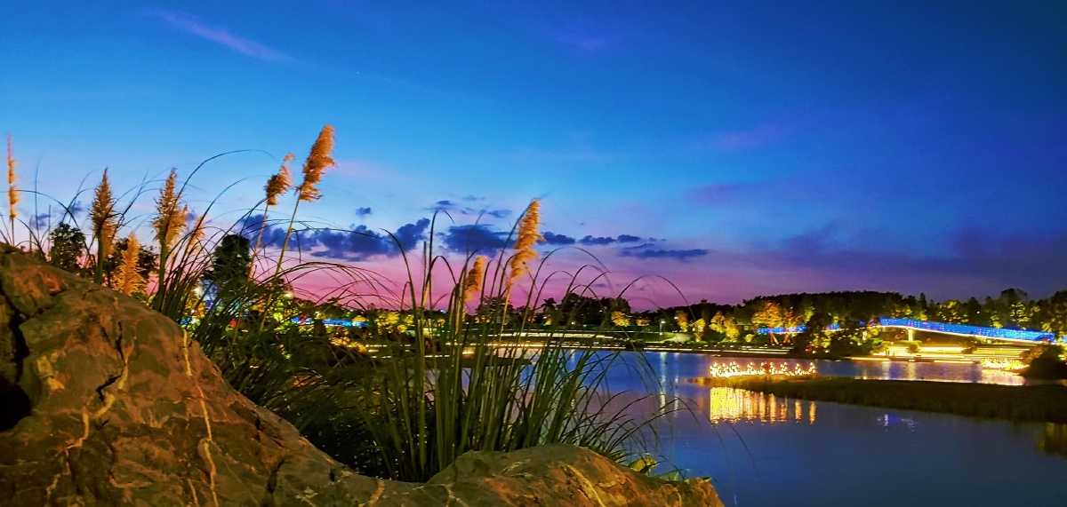 暮色无声地降落在这潮头公园日落之际天空一片深红色的云霭映照在水面