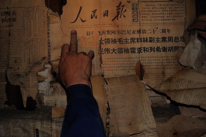 屋内墙壁上贴满了一层层报纸，第一张有的是90年代的，然后80年代，撕开最后一层，见到了一张1967年11月29日的《人民日报》<br />
