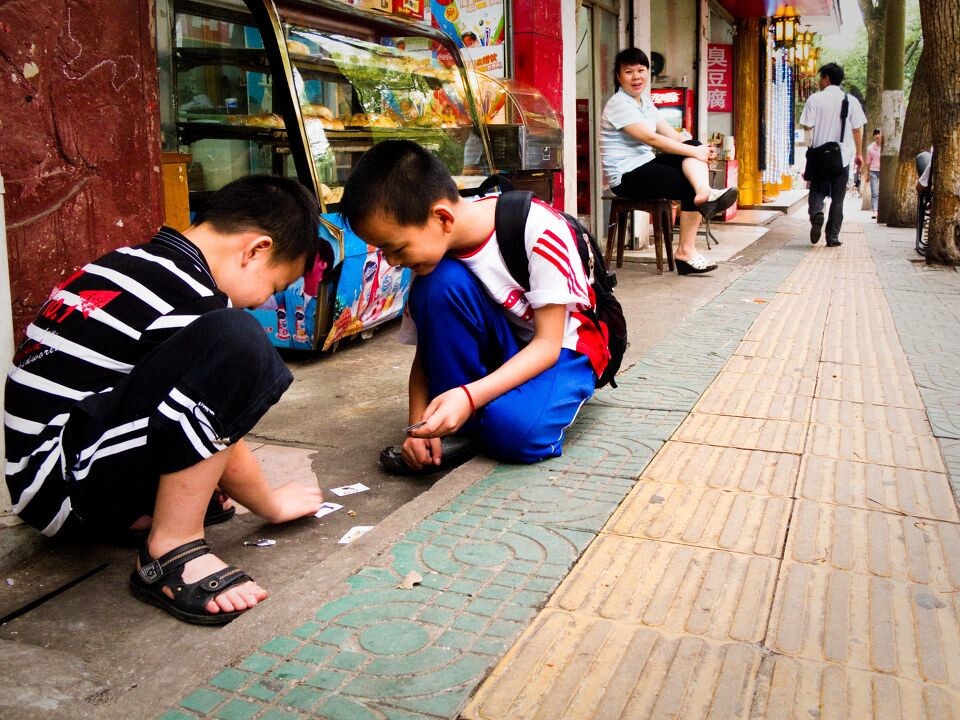 玩耍的儿童<br />
面包店前玩奇怪牌（有蜡笔小新等卡通人物…）的两小孩