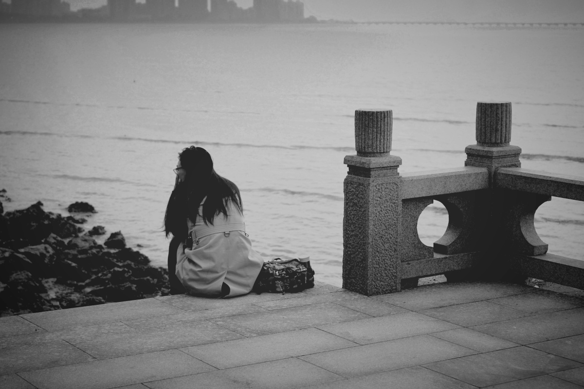 珠海早晨江边独坐的女人