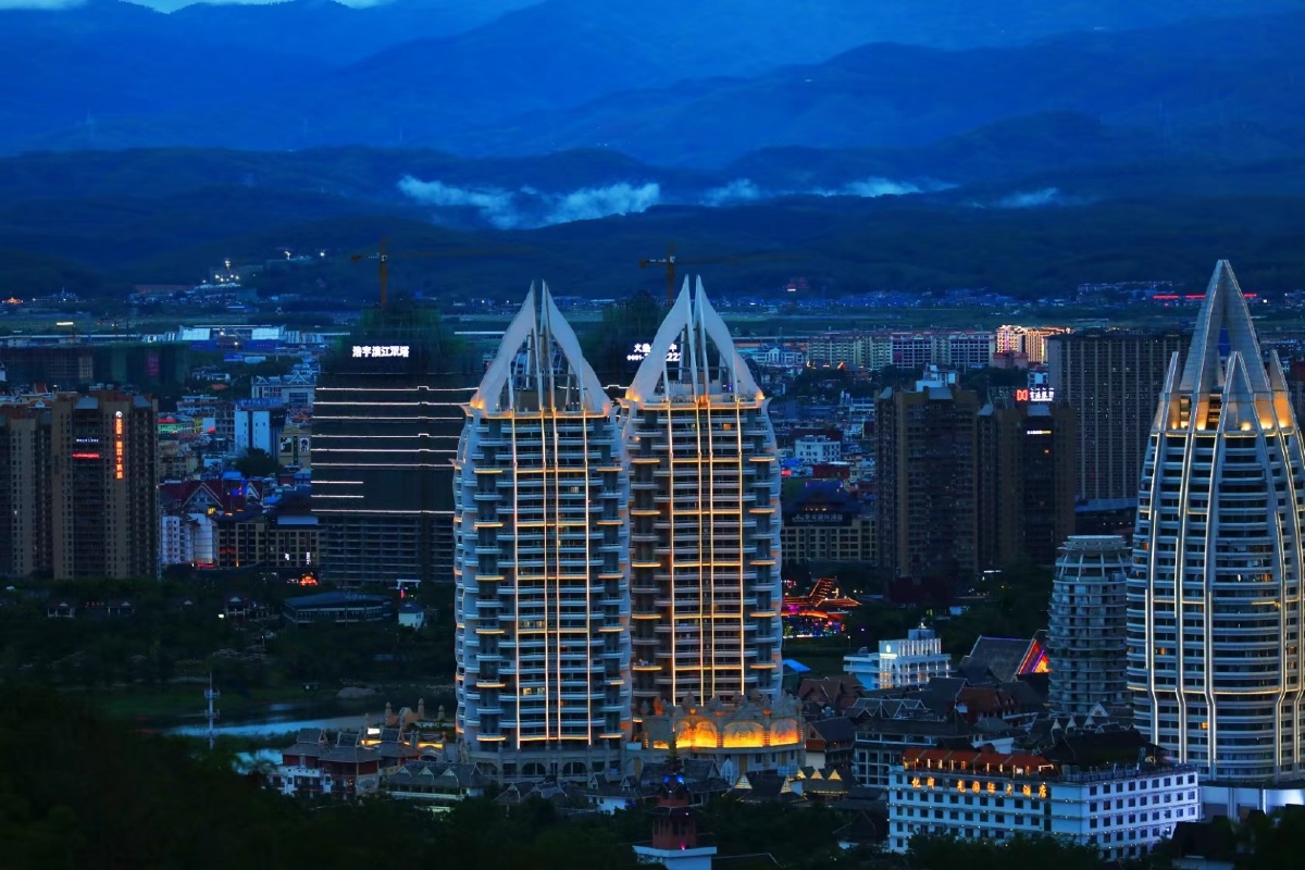 西双版纳城市建筑夜空下的双塔