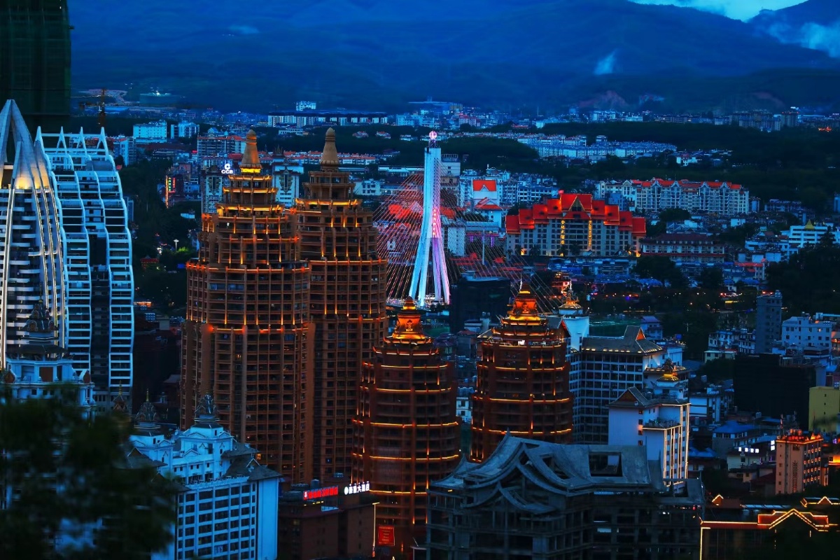 西双版纳城市建筑夜空下的双塔