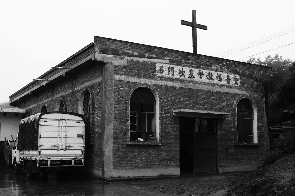 石门槛基督教福音堂雨雾中的十字架屋角的耶稣耶稣像