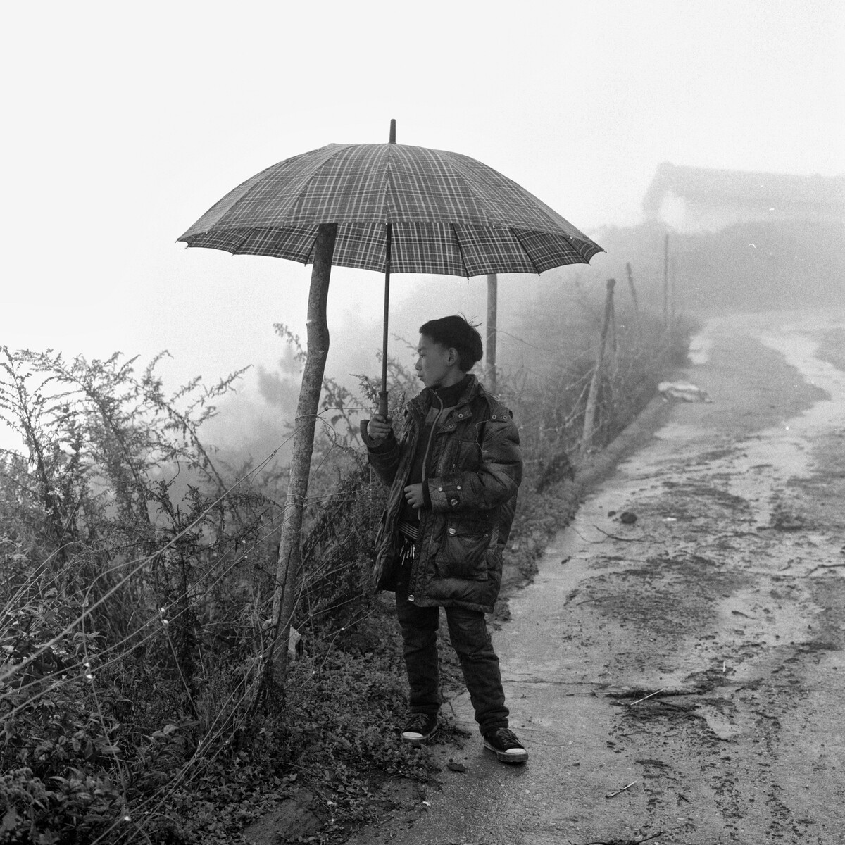 20. 雨天打伞的少年。2016年10月 拉果乡