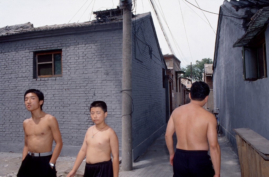 1998年摄于北京鼓楼附近。四合院里走出的膀爷。器材：尼康F5，胶片：富士PROVIA<br />
百度百科：膀爷是某些地区对夏天裸露上身在街上活动的成年男子的谑称。“膀爷”是一个颇具调侃意味与表现力的词儿，“膀”呈现了上身的赤裸状态，而“爷”字则将“膀”的主人那种旁若无人，悠然自得的神情表现得惟妙惟肖。