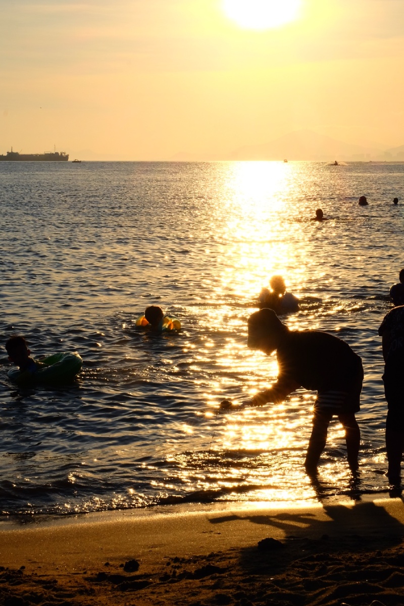映射在海面上刺的我睁不开眼有老人和孩童赤着脚在沙滩上奔跑放着风筝
