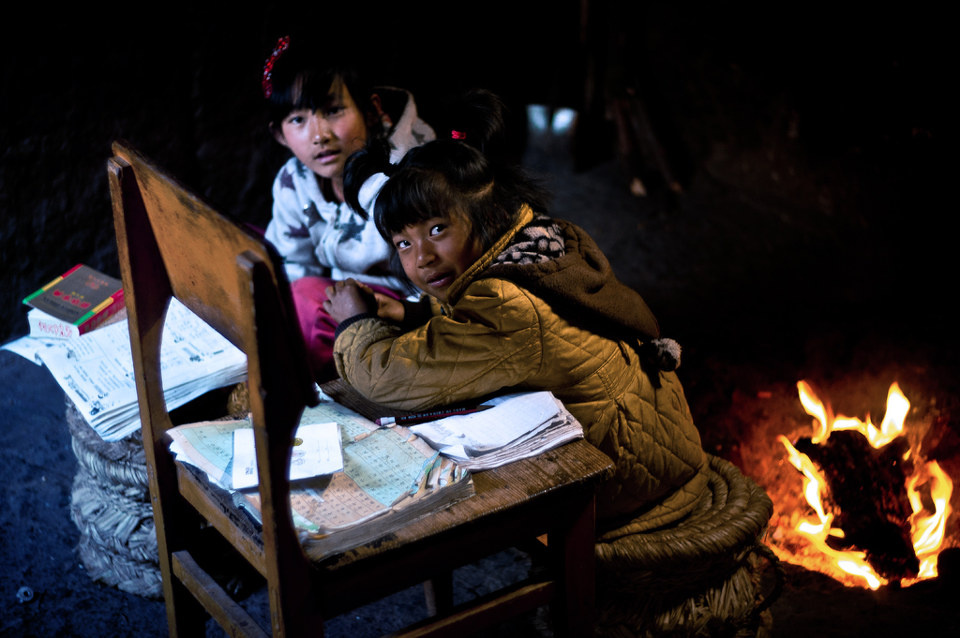 做功课 br /> 初春,在灶房里烤火做功课的女孩.