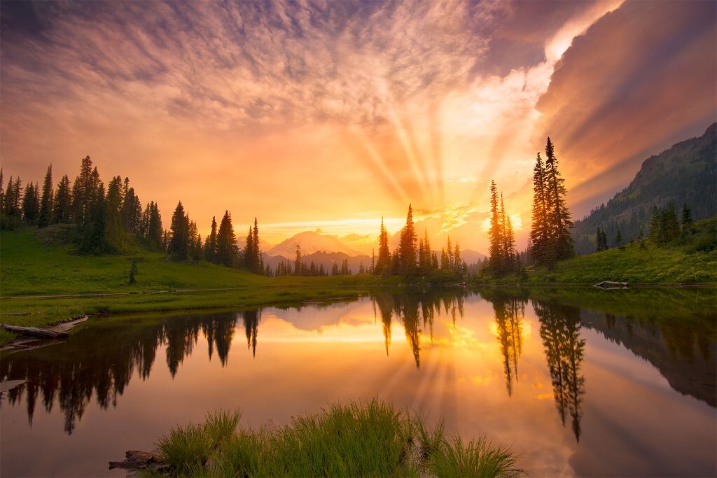 华盛顿州的Mt Rainier附近的Tipsoo Lake，我在这里等候着，终于天边万丈光芒，在远山处与阴云共舞。前两天在Rainier一直是大晴天，我一直在等待更精彩一些的天气。天气预报有风暴会出现却迟迟不来，直到我在这里的最后一个下午。离日落前一个半小时雷雨云开始形成在我身边走了个擦边向西而去，最终在日落前形成了壮观的光。