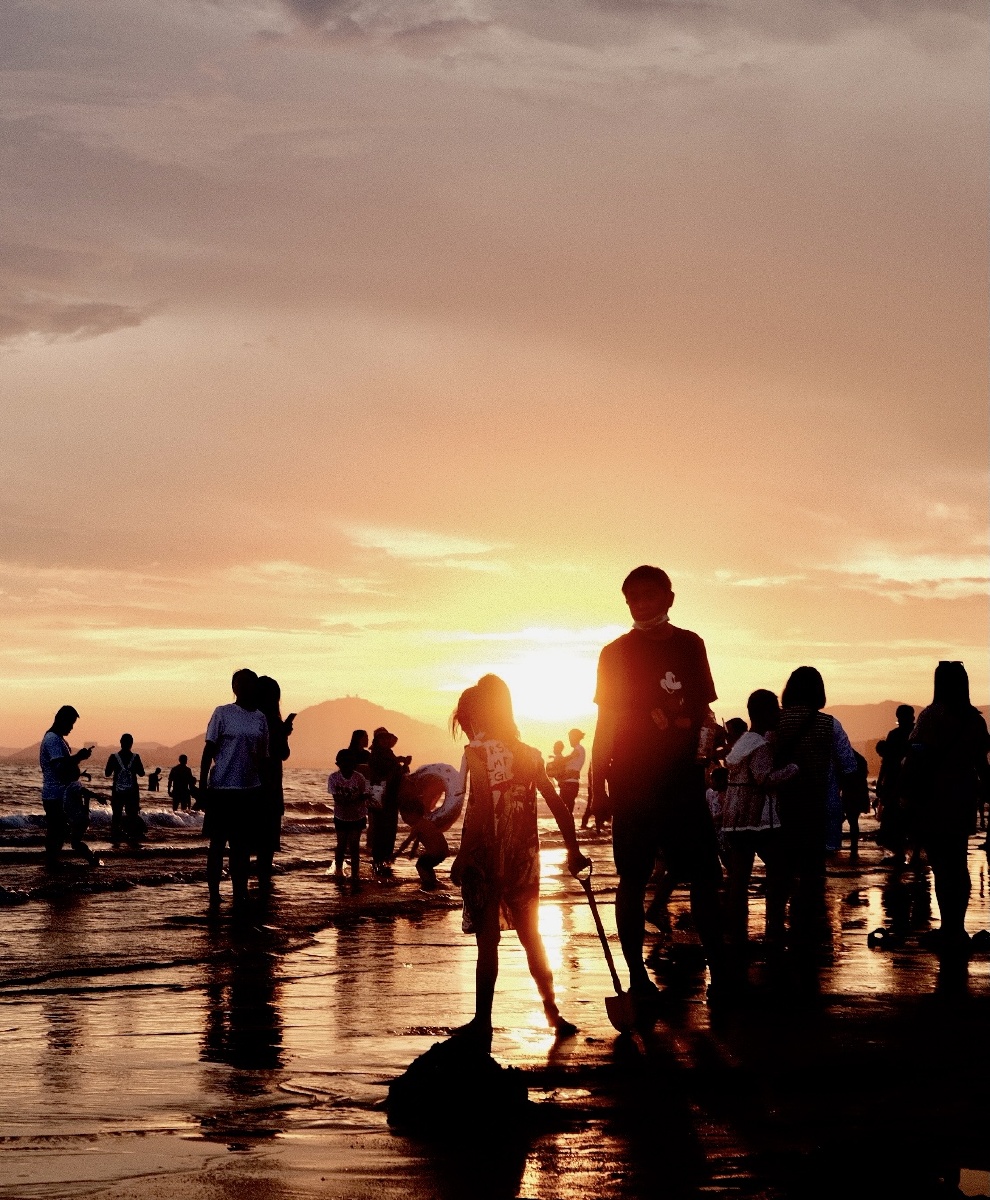 夕阳下拖着沙铲的女孩