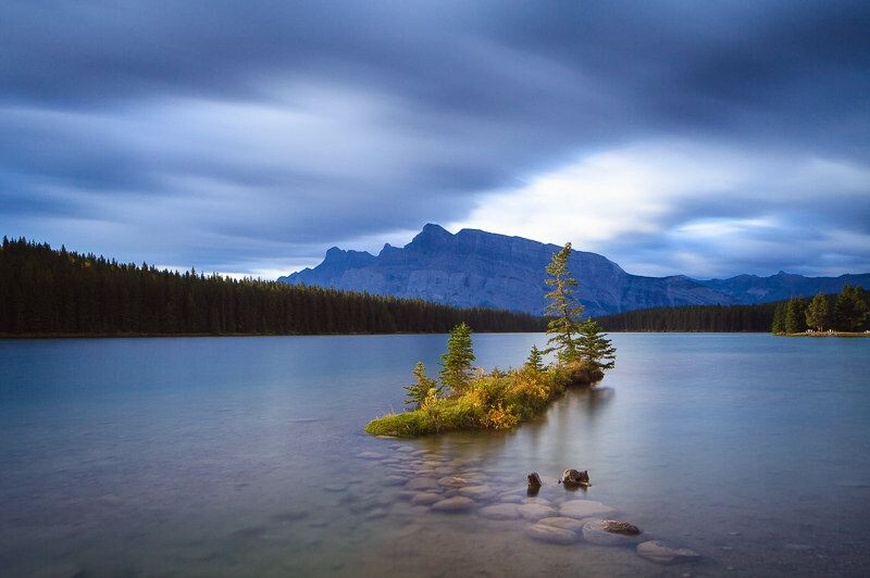 Two Jack Lake<br />
乌云密布,小雨淅淅沥沥下了起来。等着拍日出金山的都走了。站在雨里又等了1个小时。终于,太阳穿破乌云照亮小岛,就那么几十秒钟,就再也没露过头。 ISO100, 24mm, F10,120秒, 2档硬渐变灰镜,Lee big stoper10档灰镜