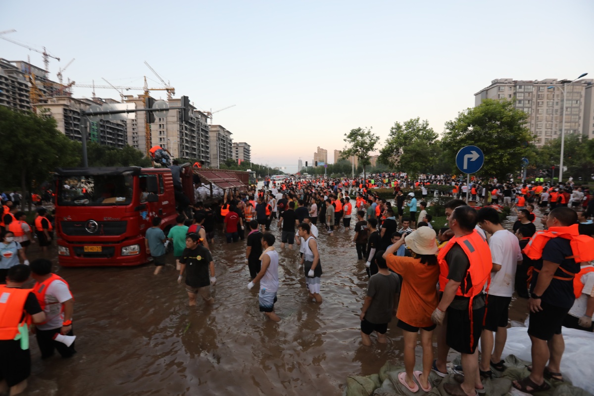 7月24日新乡市新中大道中原路口抗洪筑坝现场来自全国各地志愿者和