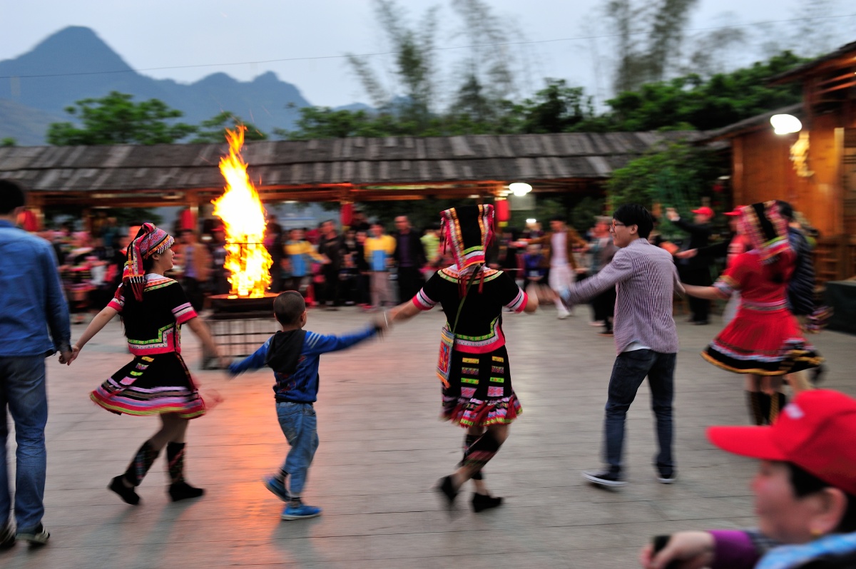 参加农家乐的游客在广西巴马县的农家院子,围着篝火跳舞