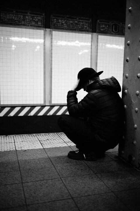 一名男子在地铁站倚着柱子小憩