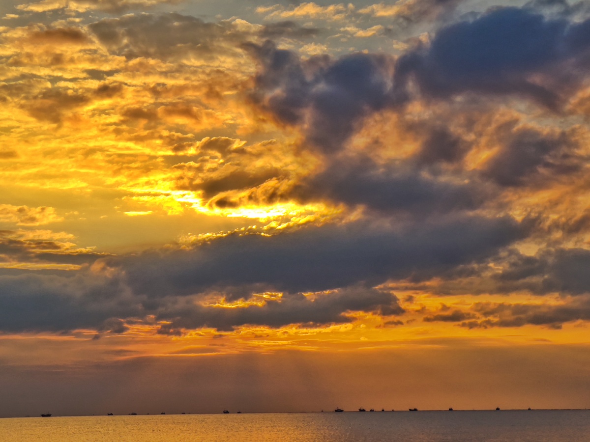 2021年夏,阿那亚.太阳将缕缕光线从云缝中投向大海.