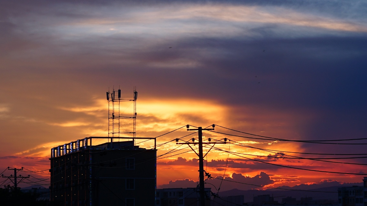 傍晚的街道车流攒动天空中的晚霞格外惹眼天桥上的人群中不时有人驻足
