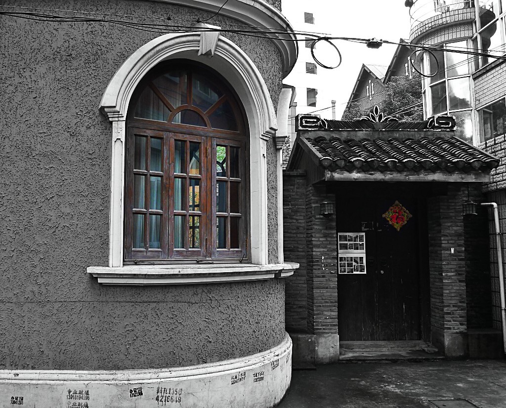 乔茗星:魔都万国建筑的突变性与渐变性魔都有万国建筑博览会之称。用一句话曾经沧海难为水形容不为过,列强,土豪在租界的建筑林林总总呈现出千姿百态于租界。<br />
魔都租界聚集了欧洲式、美国式、俄罗斯式、日本式等各式的老洋房4000至5000幢。西式建筑具有明显的阶段性,各阶段风格有明显差异,这种差异与中式建筑相比要大得多,西式建筑的变化具有突变性。因而,西式建筑明显区别中式建筑,以哥特式、拜占庭式、巴洛克式建筑为主要代表。<br />
中式建筑具有渐变性,传统中式建筑,上海保留的并不多。原因是木结构有很多缺点:易遭受火灾,白蚁侵蚀,雨水腐蚀。相比西式砖石建筑维持时间不长。<br />
中国古代建筑中也有少量砖石建筑,如《史记索隐》中称:“石室金匮,皆为国家藏书之处。”砖石结构多用于塔式建筑,但民居偏少。<br />
魔都的万国建筑大多始于鸦片战争之后,千姿万态的建筑物,源于万国建筑的突变性与中式建筑的渐变性。<br />
图片为上海一条不知名的弄堂,西洋建筑与本地民居一墙之隔相映成趣,照片取名为《西方的窗户东方的门》。<br />