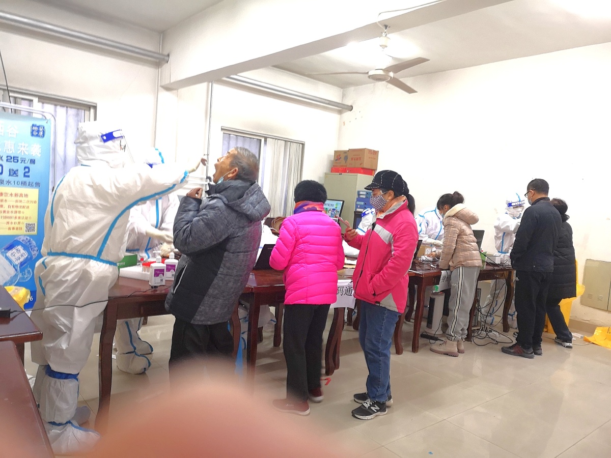 西安市防疫站工作人员正在为兴乐园小区市民免费做核酸检测