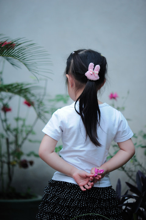 拈花 br /> 小女孩手中拈朵蔷薇花,若有所思.