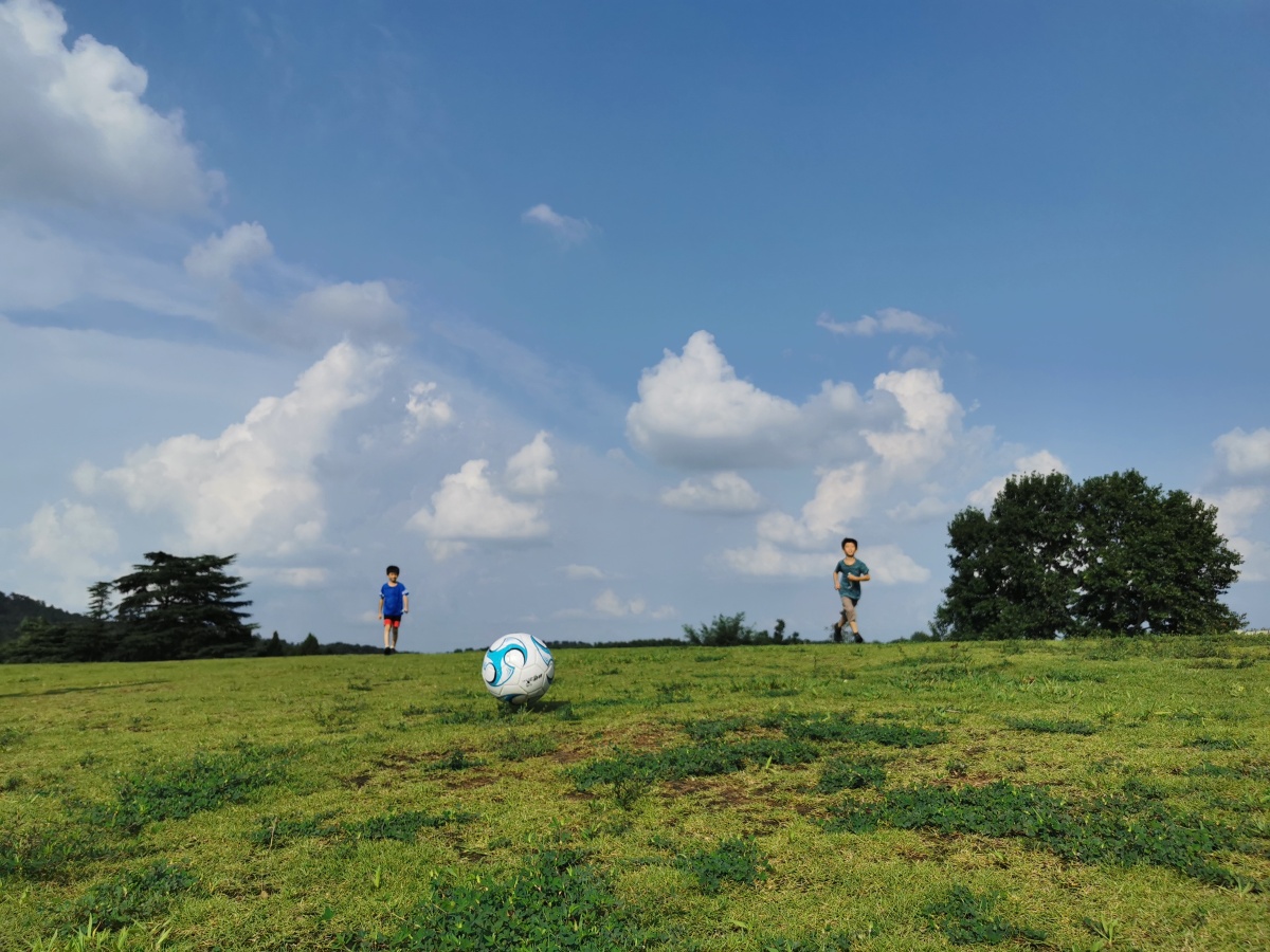 快乐的暑假一群孩子在蓝天白云下快乐的追逐奔跑,无忧无虑的踢着足球.