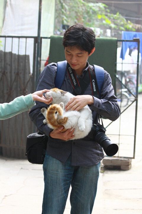 抱着校园猫的摄影学会同学<br />