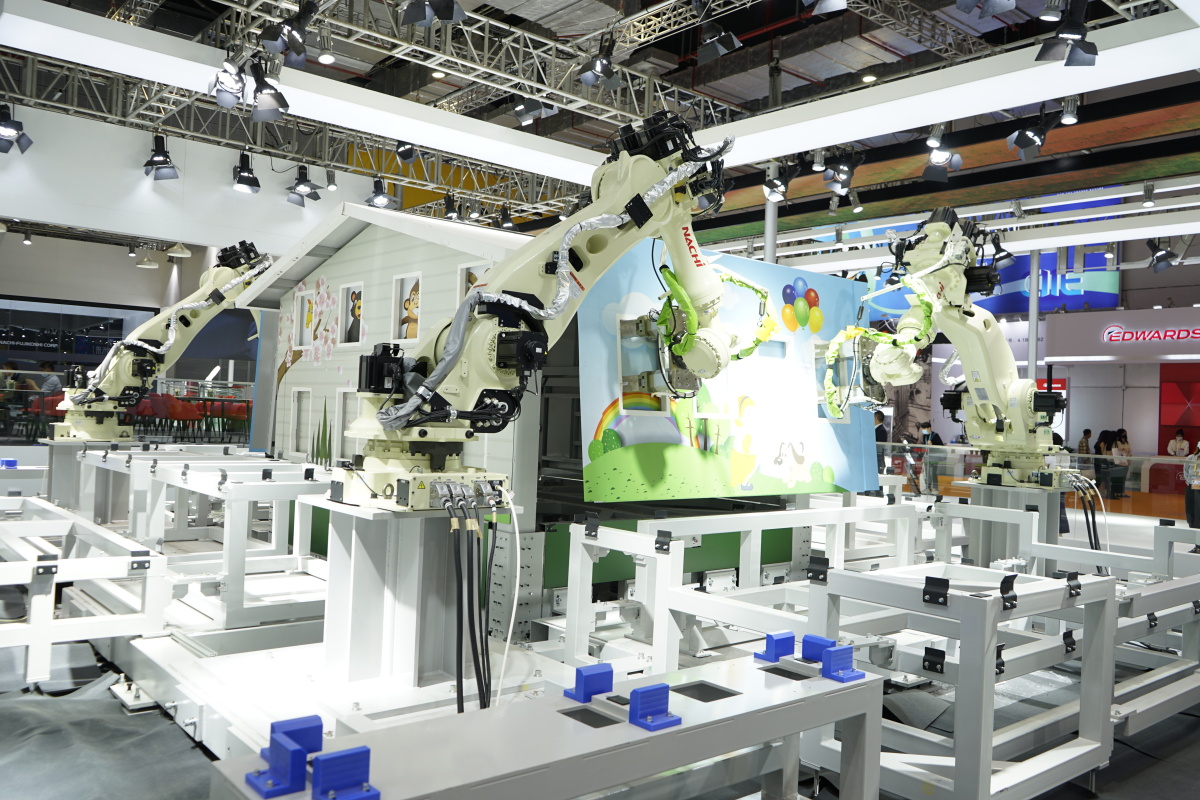 在第四届进博会技术装备展区,nahi展台,智慧工业机器人在搭建房子.