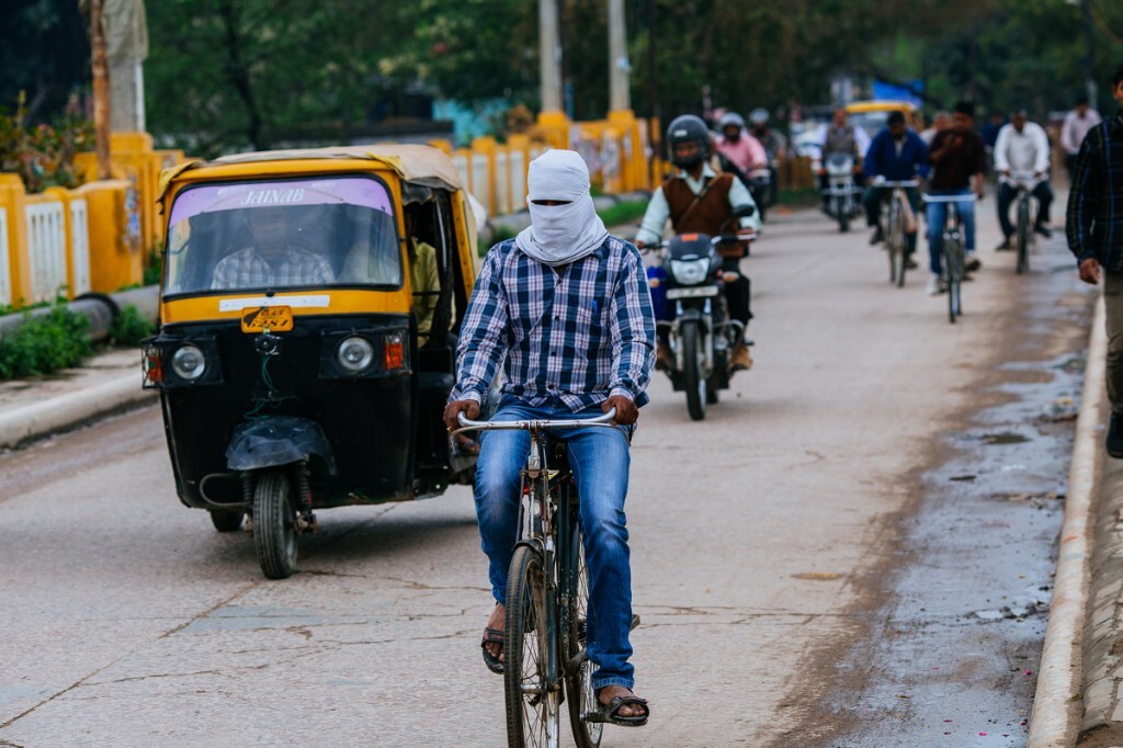 瓦拉纳西中心桥头，日落时分，下班的人群纷纷骑着自行车穿梭在路上，这位的着装让我们分不清他是信徒还是带的面罩。