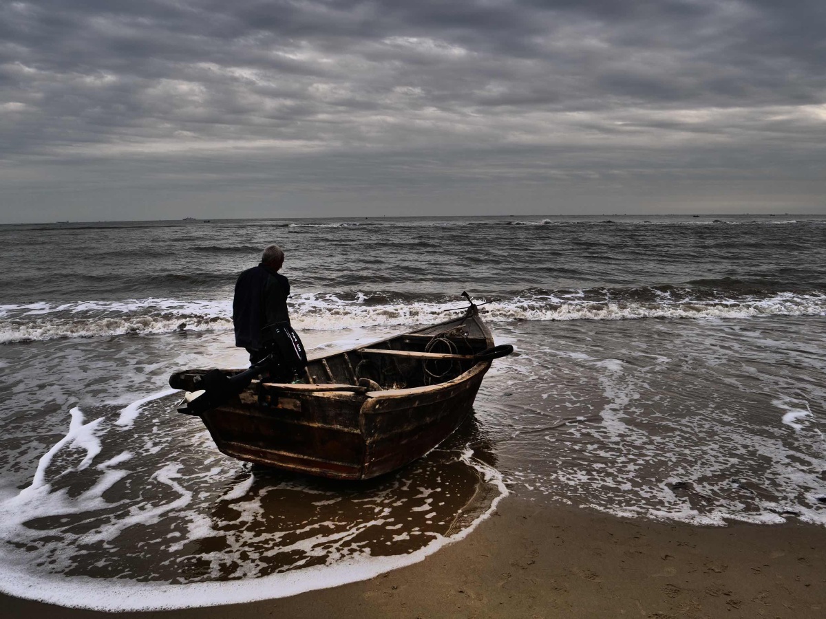 天色渐晚,渔夫出海归来正在收船,准备回家.