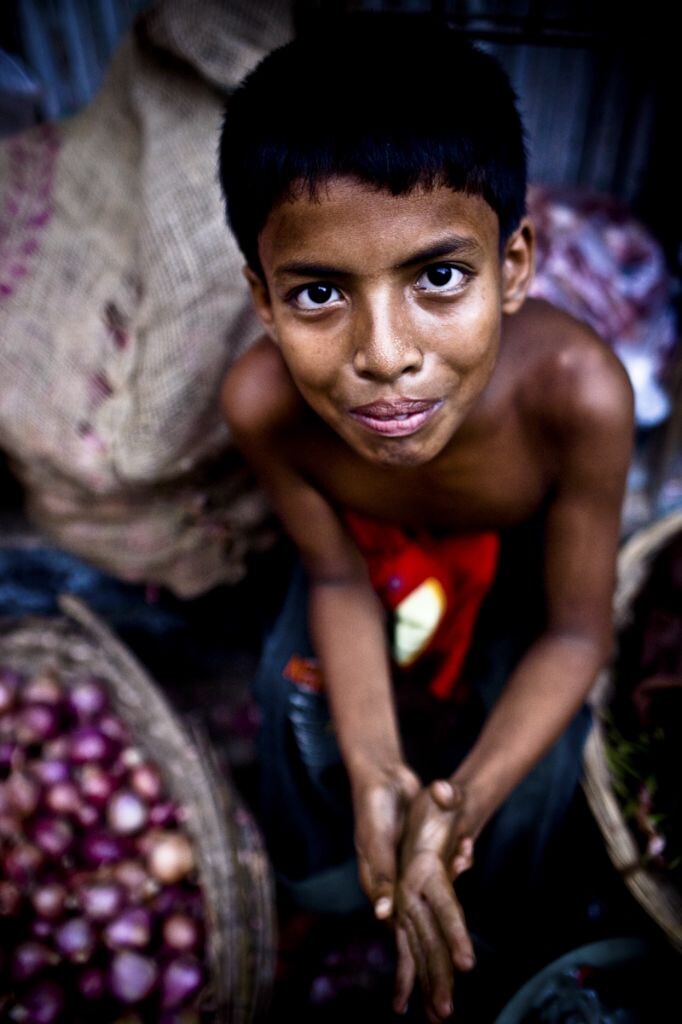 在孟加拉首都达卡一个集市上，我看到了这个害羞的买洋葱的小男孩儿
