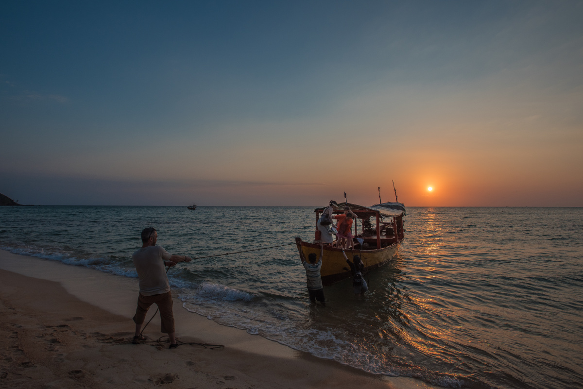 拉住小船看到正当夕阳时我立马跳下水上了沙滩先拍下这张落日下的靠岸
