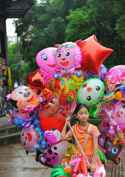 雨后酒店门口卖气球的小女孩