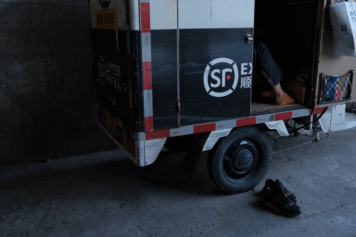 顺丰快递小哥派送快递累了在桥底下休息一会儿.