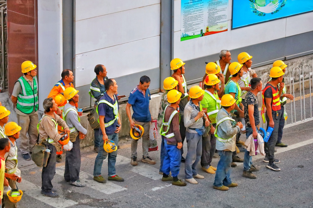 深圳地铁岗厦北站施工现场,下班等车回宿舍的工人?